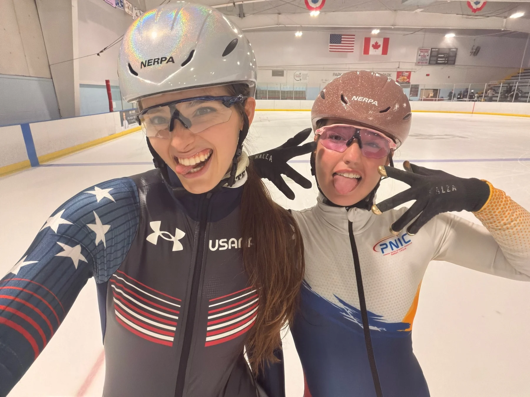 Natasa and Nastasja pulling faces in helmets at the rink